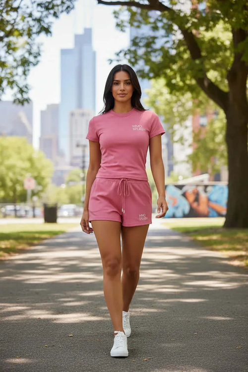 Woman walking in a park wearing a pink crop top and shorts set, showcasing MIMOSPLASH matching activewear.