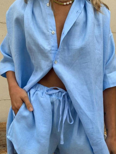 Close-up of a woman wearing a light blue women's button-up shirt and shorts set.